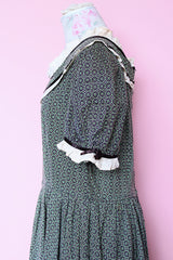 Women's vintage 1940's short sleeve maxi length cotton material prairie style dress with white and black ribbon trim around neckline and cuffs. Scalloped hem.