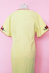 Women's vintage 1970's Wendy-Ann Inc. label short sleeve ankle length cotton material dress in bright yellow with all over red and black embroidered floral design.