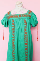 Women's vintage 1970's short sleeve cotton material green short sleeve ankle length dress with orange embroidery and a square neckline and puff sleeves.