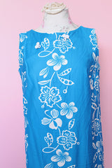 Women's vintage 1960's Made in Hawaii for Andrade Resort Shops Waikiki label sleeveless ankle length blue Hawaiian print dress with all over white floral print and white trim.