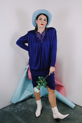 Women's vintage 1980's long sleeve knee length drapey purple slinky polyester dress with beaded trim neckline.