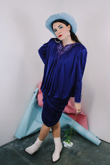 Women's vintage 1980's long sleeve knee length drapey purple slinky polyester dress with beaded trim neckline.