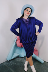 Women's vintage 1980's long sleeve knee length drapey purple slinky polyester dress with beaded trim neckline.