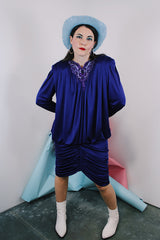 Women's vintage 1980's long sleeve knee length drapey purple slinky polyester dress with beaded trim neckline.