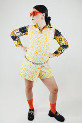 long sleeve button up polyester blouse with double lapel in an abstract orange green and black print 1970's