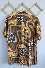 Women's or men's vintage 1970's Aloha Authentic Hand-Screened Originals label short sleeve Hawaiian print button up collared shirt in yellow, white, and brown colors.