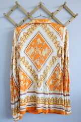 Women's vintage 1970's long sleeve button up blouse with dagger collar, darted bust, and big round clear buttons.