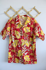 Women's or men's vintage 1970's Sundek, Made in USA label short sleeve button up shirt with dagger collar in cotton material with all over Hawaiian print in red, yellow, and green colors.