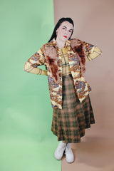 Women's vintage 1970's wool material plaid printed pleated knee length high waisted skirt. Olive green with tan, cream, and burnt orange plaid