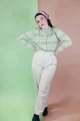 Women's vintage 1960's long sleeve button up cardigan in all wool material. Light green with an all over darker green abstract print.