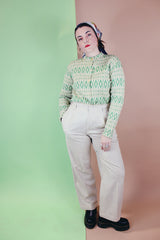 Women's vintage 1960's long sleeve button up cardigan in all wool material. Light green with an all over darker green abstract print.