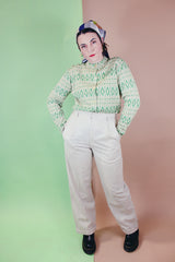 Women's vintage 1960's long sleeve button up cardigan in all wool material. Light green with an all over darker green abstract print.