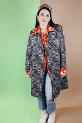 Women's vintage 1960's long sleeve long length brown and white tapestry print coat with a double breasted closure.