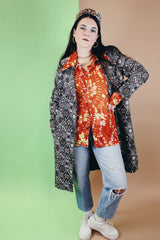 Women's or men's vintage 1970's Custom Tailored label long sleeve button up shirt with pointy collar in a lightweight Polyester material. Burnt orange with all over green and peach colored floral print.