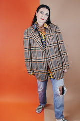 Men's vintage 1960's The Squire Shop long sleeve wool plaid print blazer with a two button closure and double lapel. Plaid print is various shades of brown.