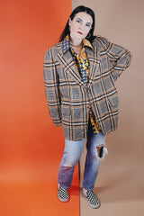 Men's vintage 1960's The Squire Shop long sleeve wool plaid print blazer with a two button closure and double lapel. Plaid print is various shades of brown.