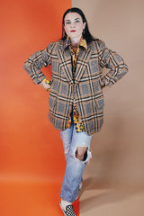 Men's vintage 1960's The Squire Shop long sleeve wool plaid print blazer with a two button closure and double lapel. Plaid print is various shades of brown.