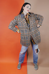 Men's vintage 1960's The Squire Shop long sleeve wool plaid print blazer with a two button closure and double lapel. Plaid print is various shades of brown.