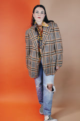 Men's vintage 1960's The Squire Shop long sleeve wool plaid print blazer with a two button closure and double lapel. Plaid print is various shades of brown.