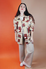 Men's vintage XL 1970's Paul Howard California label long sleeve button up shirt with a pointy collar in a silky soft polyester material with tan, brown, blue, green, and yellow all over abstract print.