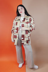 Men's vintage XL 1970's Paul Howard California label long sleeve button up shirt with a pointy collar in a silky soft polyester material with tan, brown, blue, green, and yellow all over abstract print.