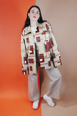 Men's vintage XL 1970's Paul Howard California label long sleeve button up shirt with a pointy collar in a silky soft polyester material with tan, brown, blue, green, and yellow all over abstract print.