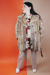 Women's vintage 1960's long sleeve knee length faux fur tan coat with leather trim. Has a matching leather belt, gold twist buttons, and pockets