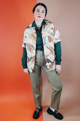 Men's vintage 1970's Jandy Place, Bardon Inc. label short sleeve button up shirt with a pointy collar in a silk like polyester material cream colored with all over brown and blue abstract print.