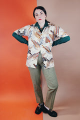 Men's vintage 1970's Jandy Place, Bardon Inc. label short sleeve button up shirt with a pointy collar in a silk like polyester material cream colored with all over brown and blue abstract print.