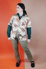 Men's vintage 1970's Jandy Place, Bardon Inc. label short sleeve button up shirt with a pointy collar in a silk like polyester material cream colored with all over brown and blue abstract print.