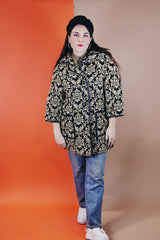 Women's vintage 1960's black and tan tapestry printed button up coat with black leather trim, two front pockets, and a rounded peter pan collar