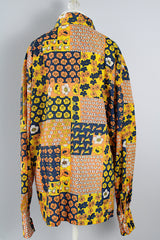 Men's vintage 1970's SKYR label long sleeve button up shirt with a pointy collar in a orange, yellow, and navy patchwork floral print in a lightweight Nylon material.