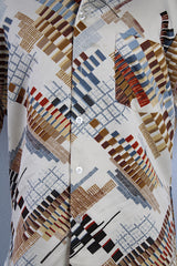 Men's vintage 1970's Jandy Place, Bardon Inc. label short sleeve button up shirt with a pointy collar in a silk like polyester material cream colored with all over brown and blue abstract print.