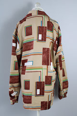Men's vintage XL 1970's Paul Howard California label long sleeve button up shirt with a pointy collar in a silky soft polyester material with tan, brown, blue, green, and yellow all over abstract print.