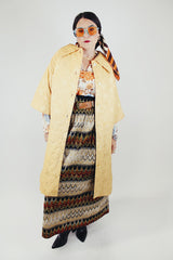 gold colored quilted duster jacket buttons up the front with collar and moon and star all over print