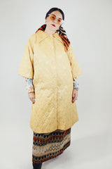 gold colored quilted duster jacket buttons up the front with collar and moon and star all over print