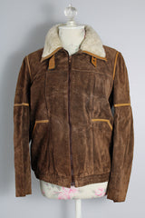 Women's vintage 1970's Ms. Pioneer label long sleeve brown suede short zip up jacket with cream faux fur trim on collar.