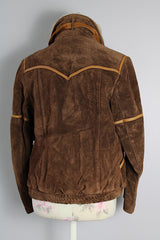 Women's vintage 1970's Ms. Pioneer label long sleeve brown suede short zip up jacket with cream faux fur trim on collar.