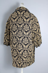 Women's vintage 1960's black and tan tapestry printed button up coat with black leather trim, two front pockets, and a rounded peter pan collar