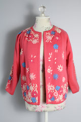 Women's vintage 1950's Gene Shelly's Miss Boutique California label 3/4 arm length open front pink cardigan sweater in wool material with blue, white, and pink embroidered flowers all over