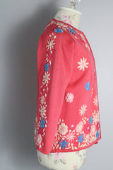 Women's vintage 1950's Gene Shelly's Miss Boutique California label 3/4 arm length open front pink cardigan sweater in wool material with blue, white, and pink embroidered flowers all over
