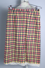 Women's vintage 1970's high waisted midi length pencil skirt in cream with yellow, red, and black plaid print in a wool material