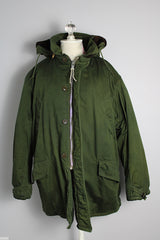Men's vintage 1940's Army B-940 parka coat in arm green color, cotton material with nylon quilted. Faux fur hooded detachable hood, zipper and buttons closure up the front.