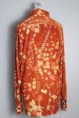 Women's or men's vintage 1970's Custom Tailored label long sleeve button up shirt with pointy collar in a lightweight Polyester material. Burnt orange with all over green and peach colored floral print.