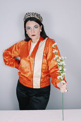 Women's or men's vintage 1940's/1950's long sleeve equestrian racing top in orange satin with one cream vertical stripe.