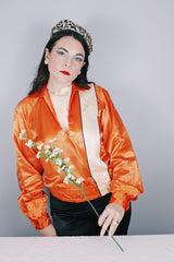 Women's or men's vintage 1940's/1950's long sleeve equestrian racing top in orange satin with one cream vertical stripe.