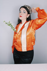 Women's or men's vintage 1940's/1950's long sleeve equestrian racing top in orange satin with one cream vertical stripe.