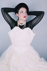 Women's vintage 1950's white lace wedding dress with cream satin bodice and lace overlay. Sweetheart neckline, strapless, zipper in the back.