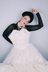 Women's vintage 1950's white lace wedding dress with cream satin bodice and lace overlay. Sweetheart neckline, strapless, zipper in the back.