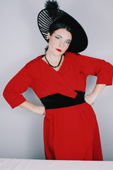 Women's vintage 1950's Jr. Plenty Shop, Lane Bryant label 3/4 arm length midi length red dress with V shaped neckline, black velvet waistband and double lapel collar.